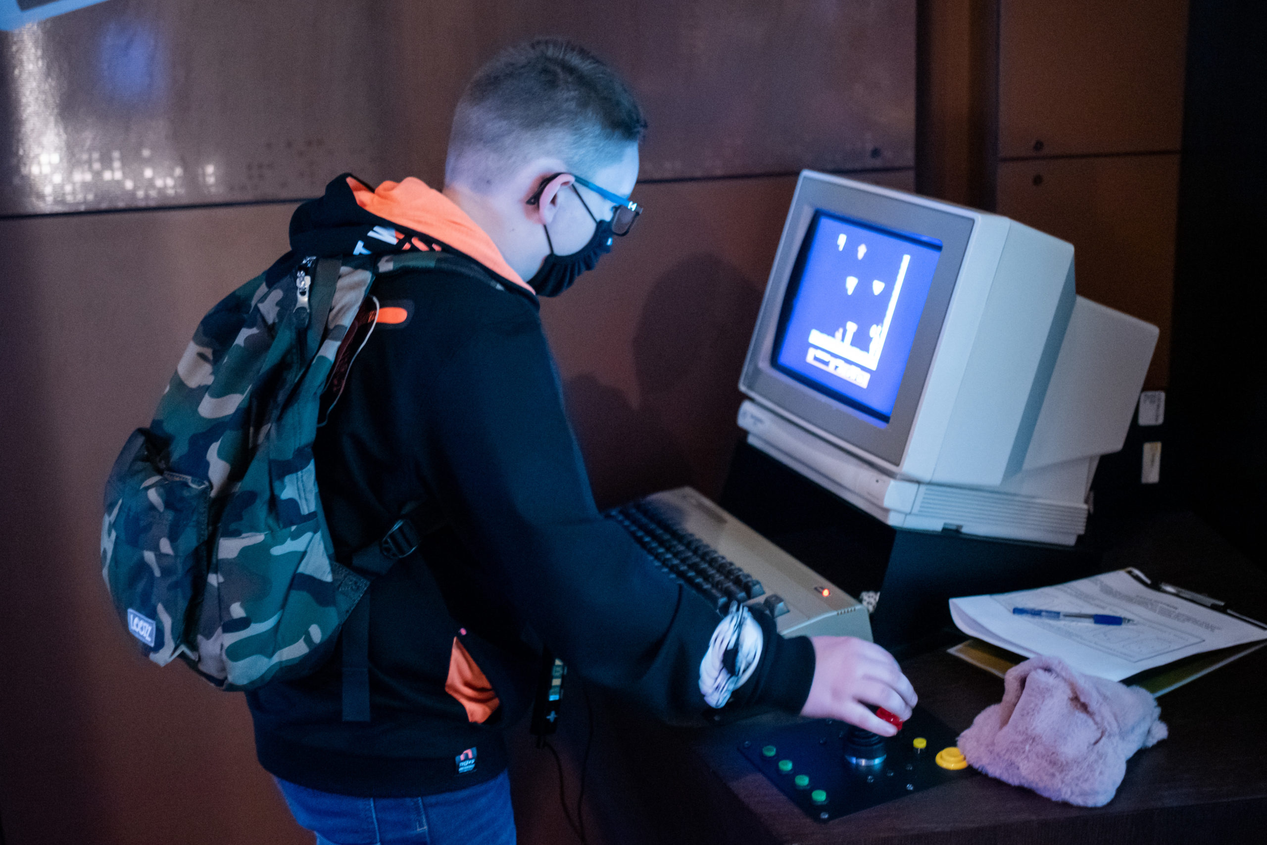 Uczeń gra w retro grę na komputerze.